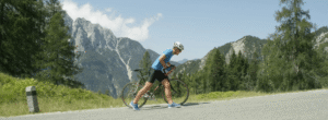 Cycliste déçu poussant son vélo en montée : apprendre à gérer ses émotions après un échec